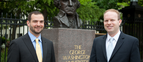 Keith Stefanelli and Daniel Kaniewski smile in front of George Washington bust on university campus