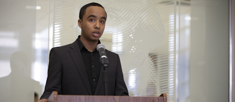 Karl Delatour speaks at podium into microphone