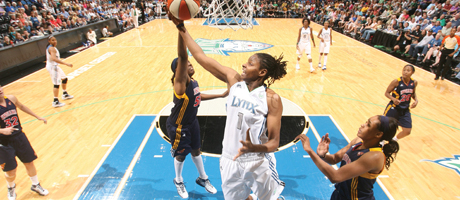 Jessica Adair shoots basketball during a game with players defending her