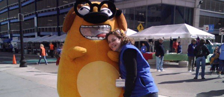 Joanna Rothman with a costumed Ruff Ruffman. The two have their arms around each other. 