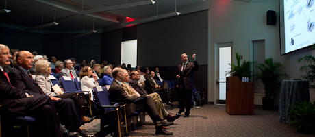 Steve Lerman points to screen while lecturing to an audience