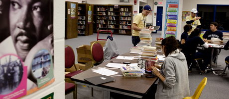 students completing community service in library working with books