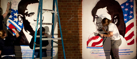 students painting murals on wall of President Obama and Michelle Obama