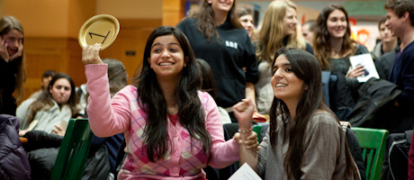 students celebrating at Martha's Marathon event holding up bidding plates 