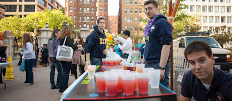 students surrounding table with nonalcoholic beverages on Kogan Plaza