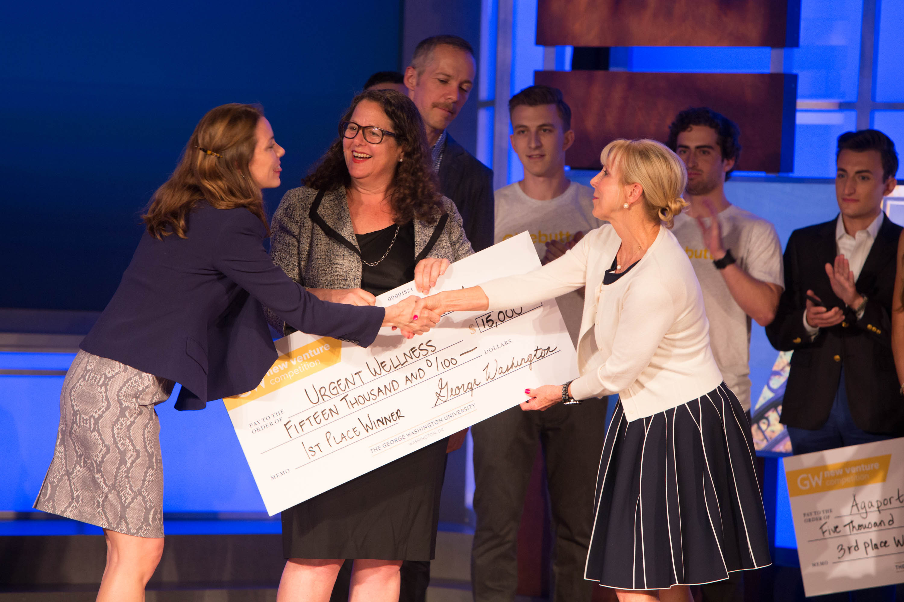 New Venture Competition winner accepts oversized check on stage