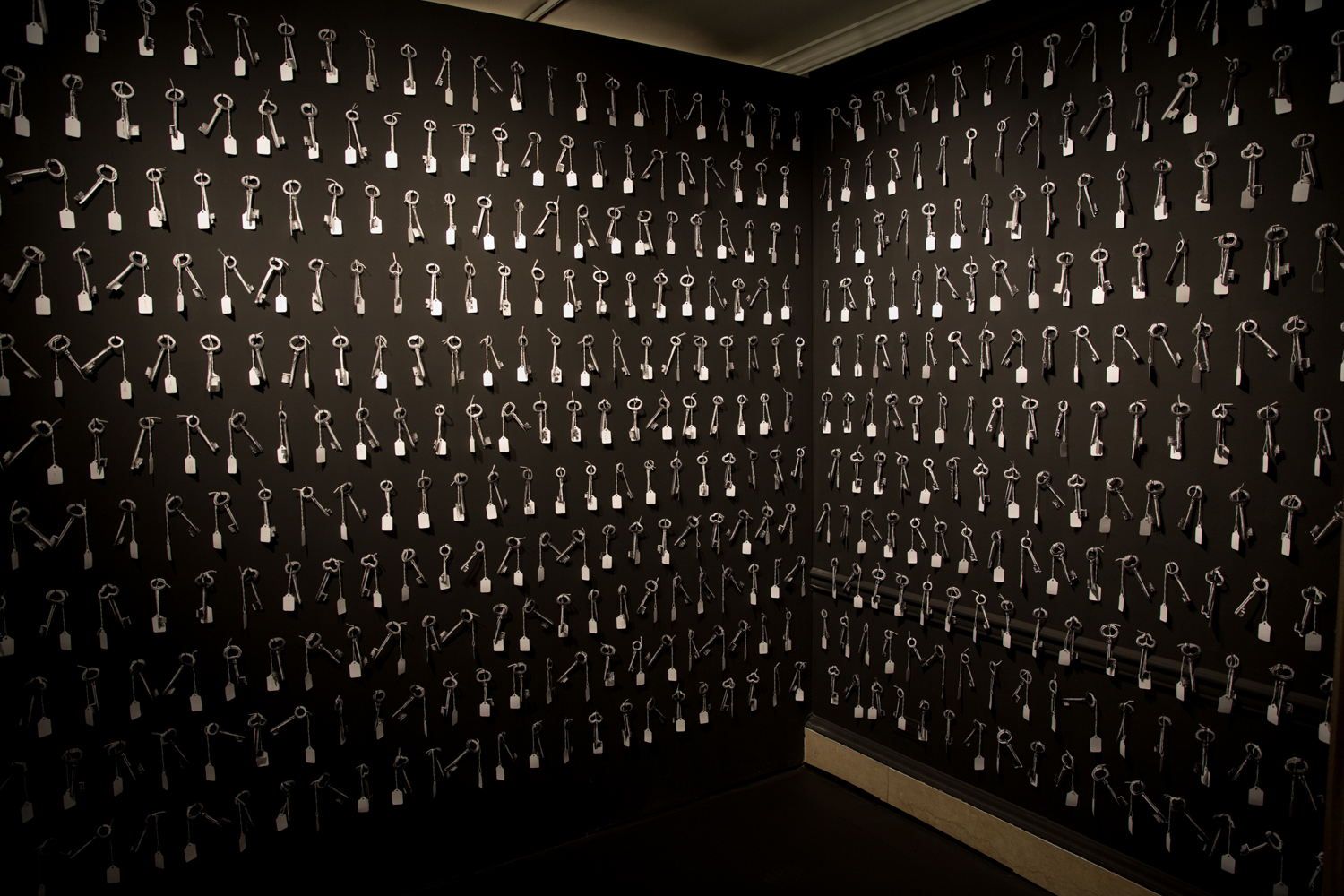 A black-painted room with keys nailed all over the walls.