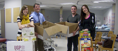 physical therapy students hold a canned food drive and stand with boxes and cans