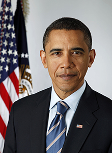 President Obama smiles with American flag draped behind him