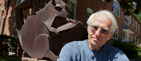 Berthold Schmutzhart sits in front of Professor Who sculpture and smiles