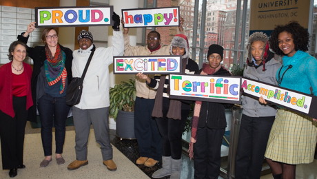 Project Search members hold up signs, "proud," "happy," "excited," "terrific," and "accomplished" 