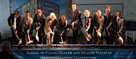 Members of the university community join as a group holding shovels in groundbreaking for SPHHS building