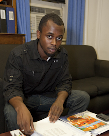 Sam Collins sits with notebook on table