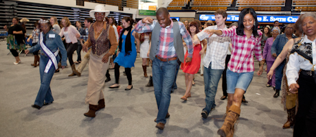 students and senior citizens line dancing on floor of Smith Center