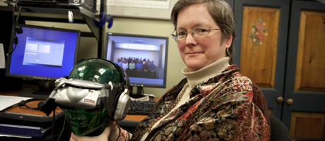 Shelly Brundage smiles in office at desk holding virtual reality headset