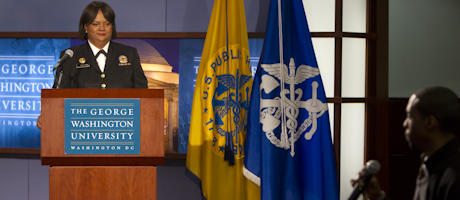 Surgeon General Vice Admiral Regina M. Benjamin speaks at podium with the George Washington University plaque