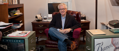 Tom Mallon seated on leather chair smiling in office