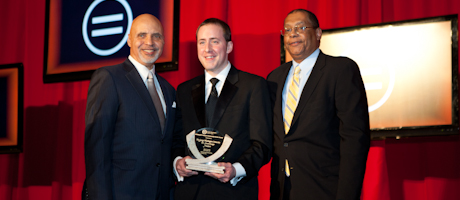 Jerry A. Moore III, Michaal Akin and Earle F. Jones stand with glass award