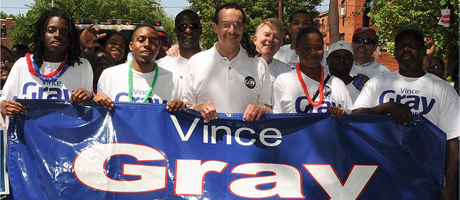 Vincent Gray holds a banner with his name on it with volunteers from campaign