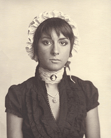A Belle of Modernity photo, young woman in bonnet, black dress and a neck clothes with nose pierced