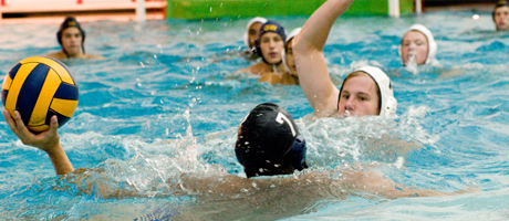 Water polo players in pool with one player holding a ball 