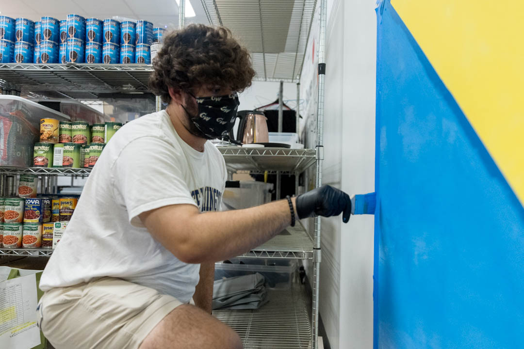 Peyton Pavy, a first-year student majoring in political science and history, paints a mural at The Store in District House.