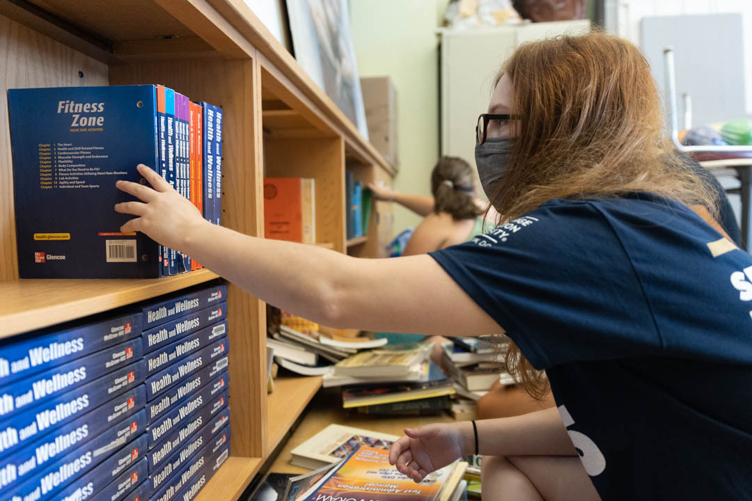 Sarah Pinkaw, a first-year student majoring in international affairs, organizes a book shelf at the School Without Walls during Welcome Days of Service.