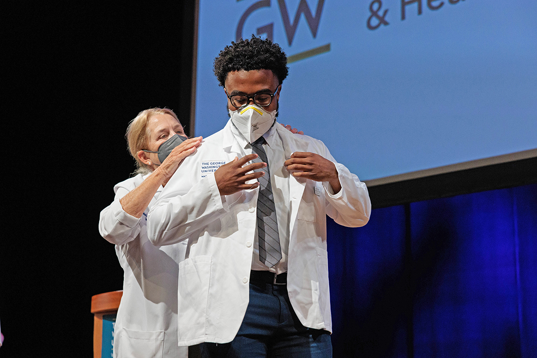 student receiving white coat