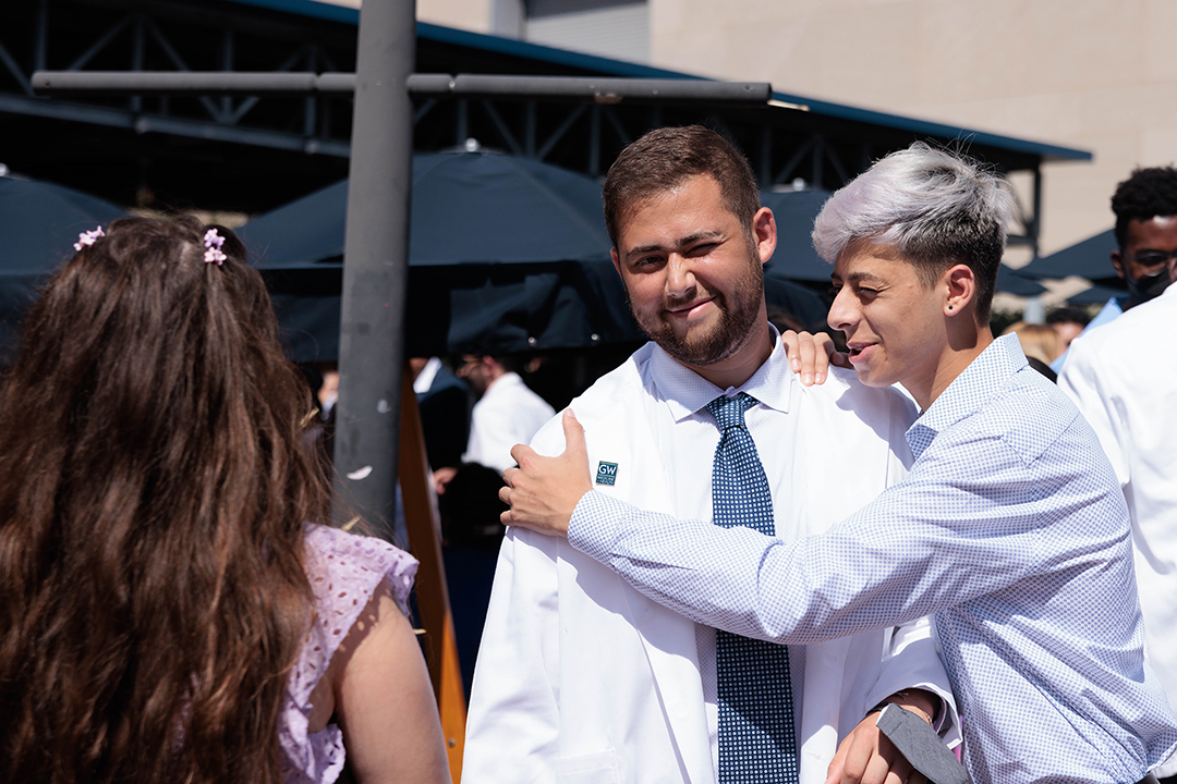 student celebrates with hugs after ceremony