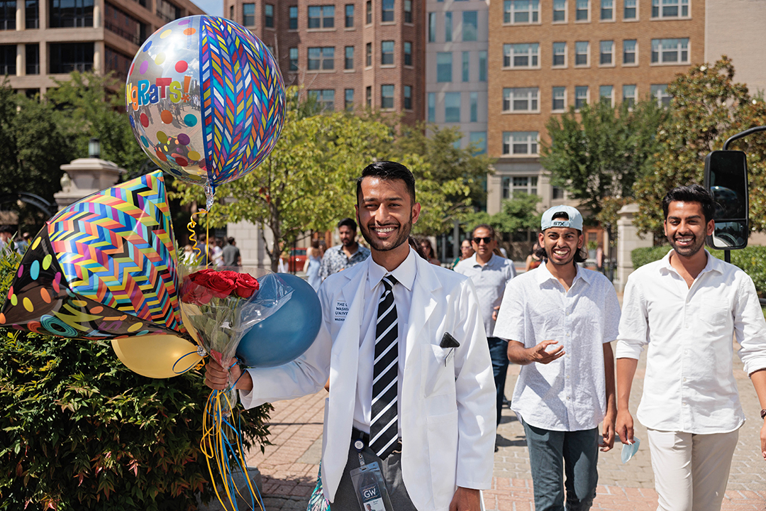 Student with balloons after ceremony