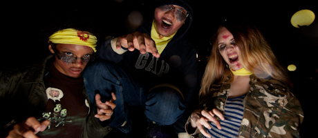 Students in makeup posing as zombies with mouths open and arms outstretched in front