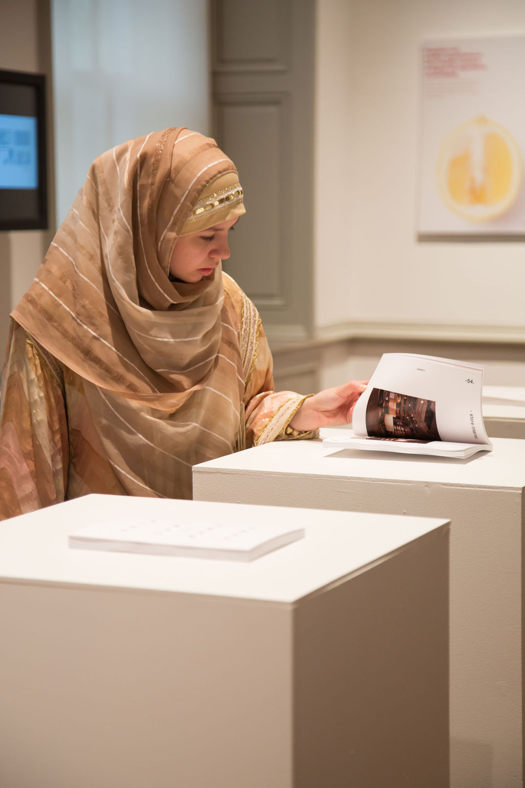 student looking at NEXT brochure on podium