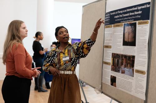 Art therapy master’s student LauraChioma Jones showing her poster at the CCAS Research Showcase
