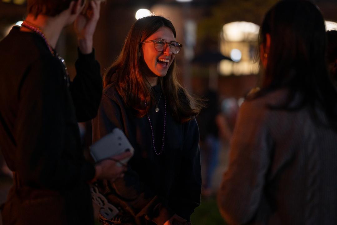 Student smiling at bonfire