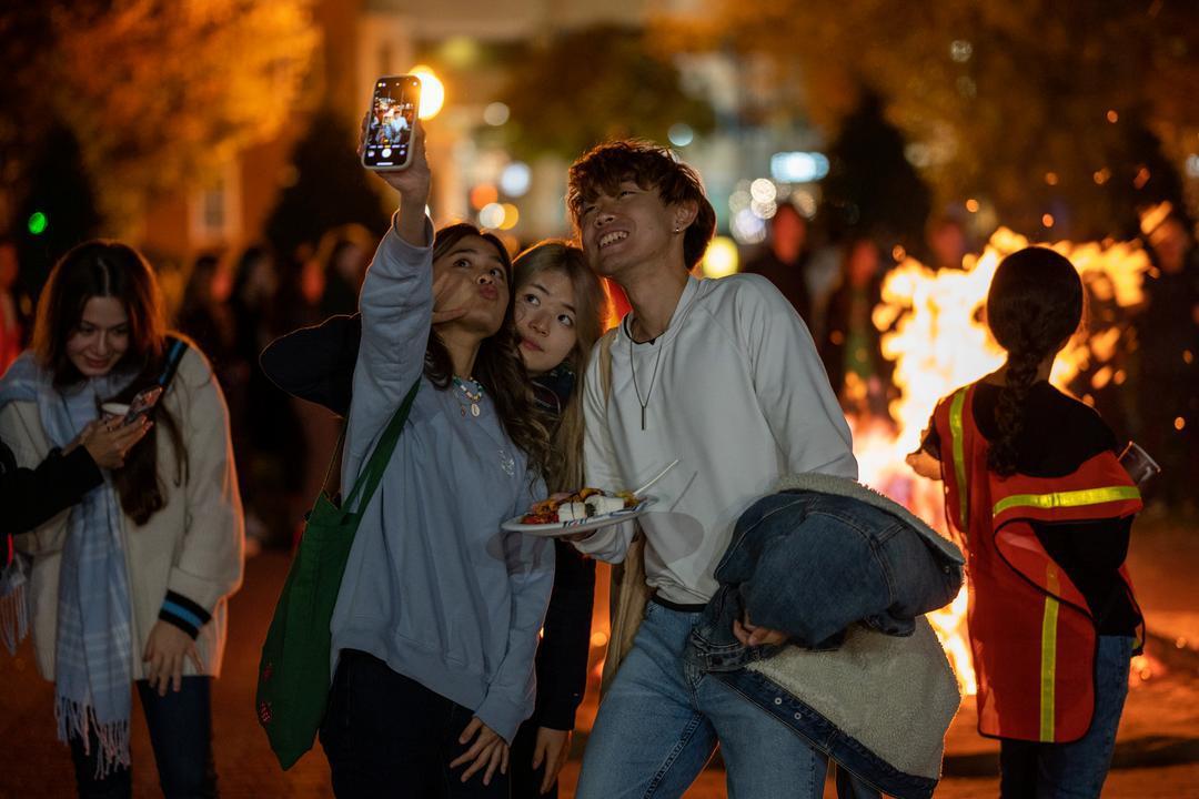 Students taking a selfie at bonfire 