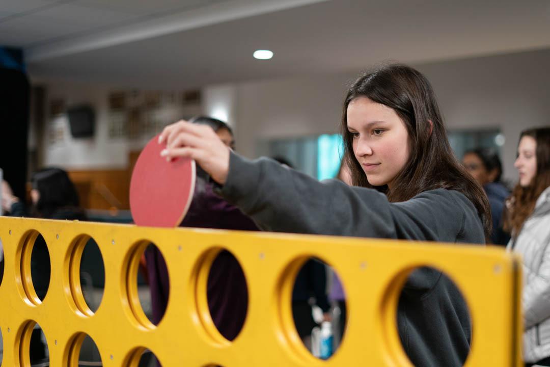 Student placing connect 4 piece