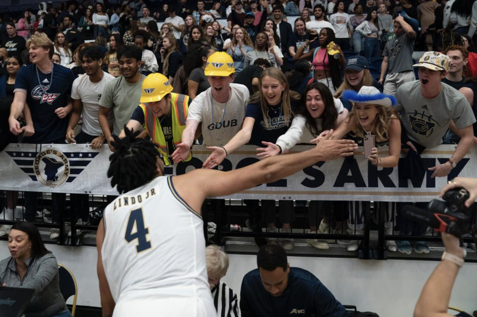 GW basketball player Lindo Jr high fives fans in the stands