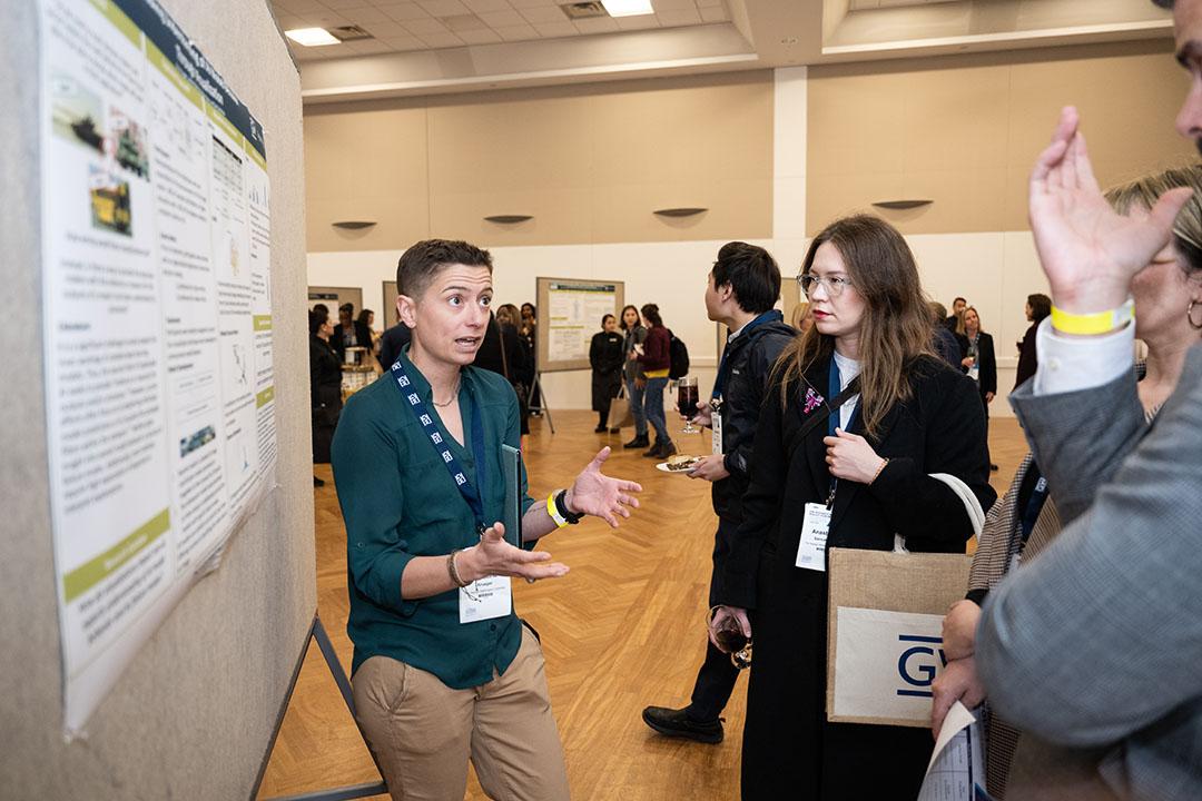GW student explains her research at poster presentation at GWSB Policy Forum on AI.