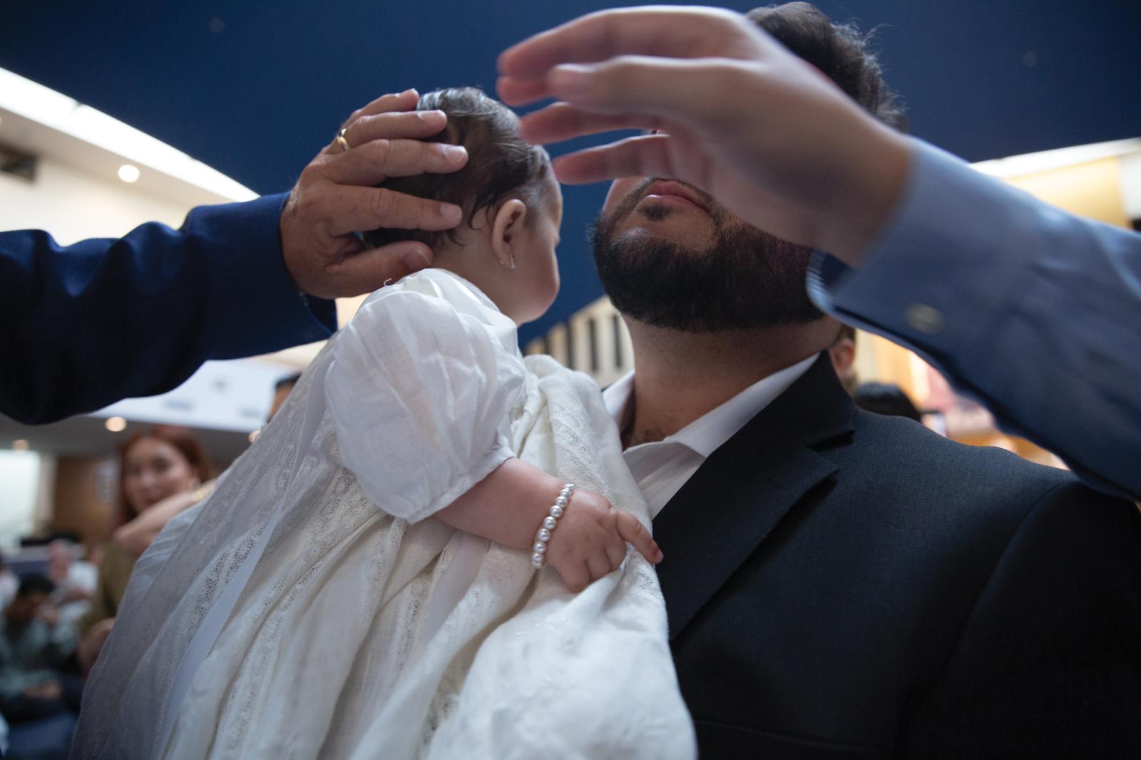 An infant is held at a baptismal ceremony