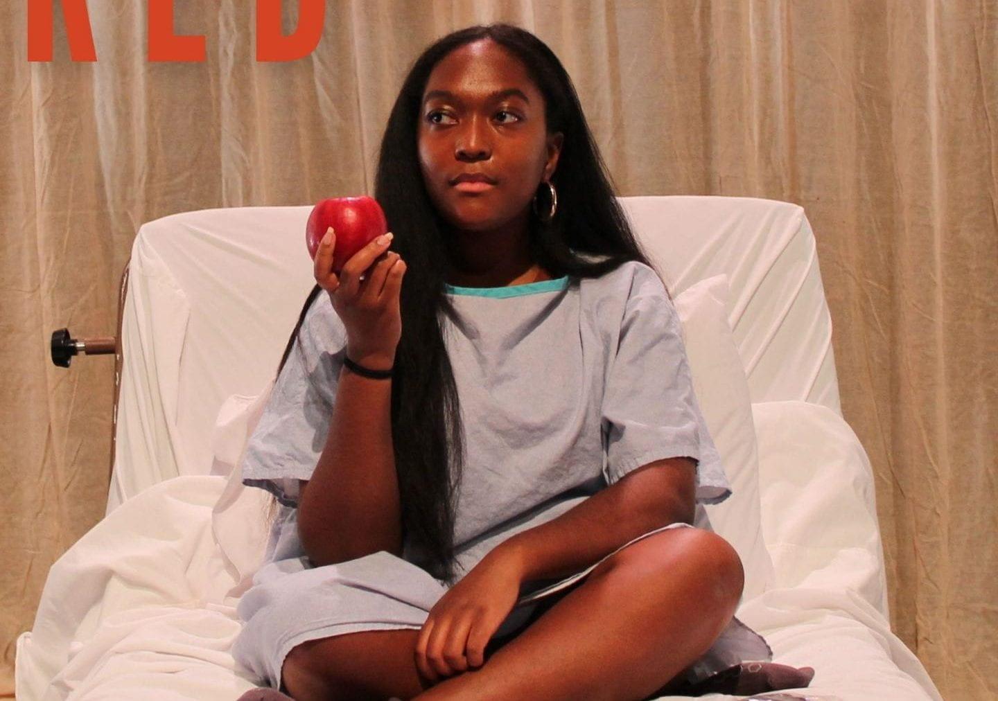 Image of person holding an apple in a hospital bed