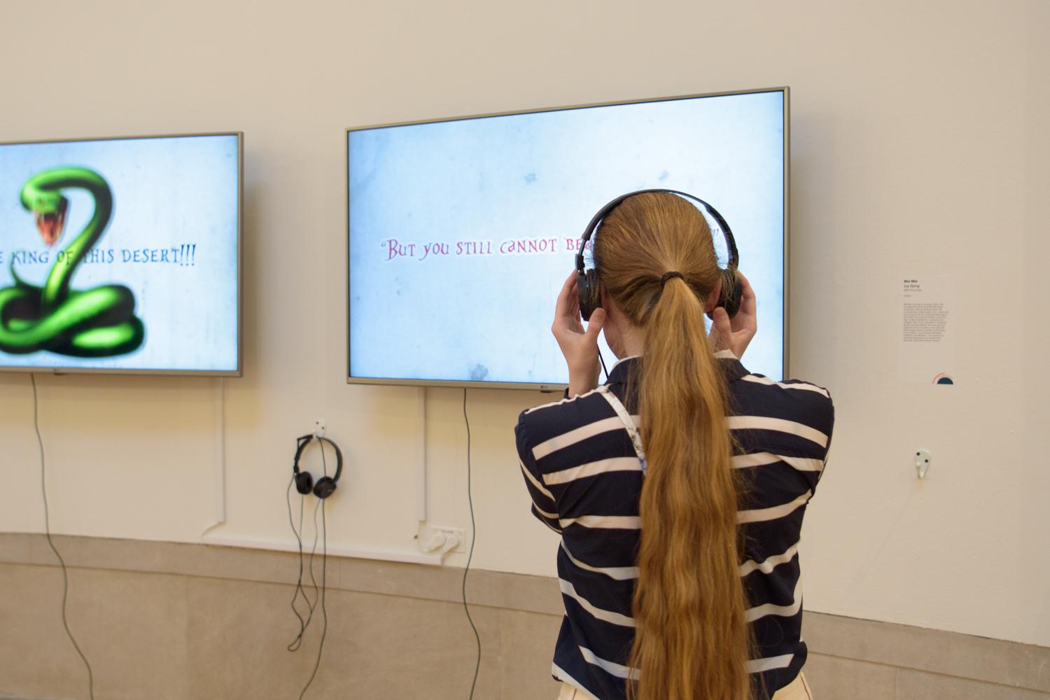 student with headphones on looking at exhibit