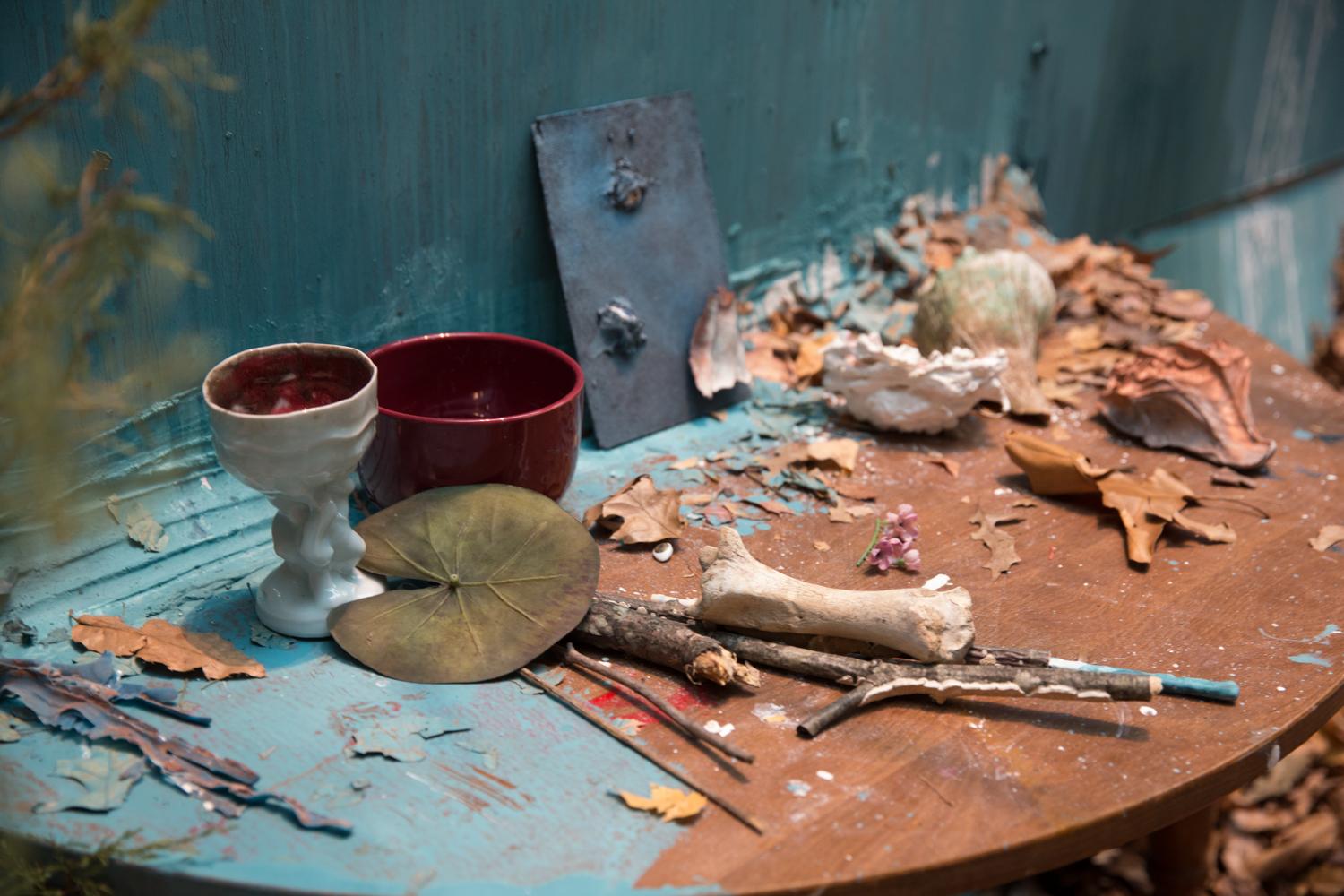 A close up view sticks and crumpled leaves and handmade ceramic chalices, from Senior Whitney Waller's immersive, fall-themed "Dasein."