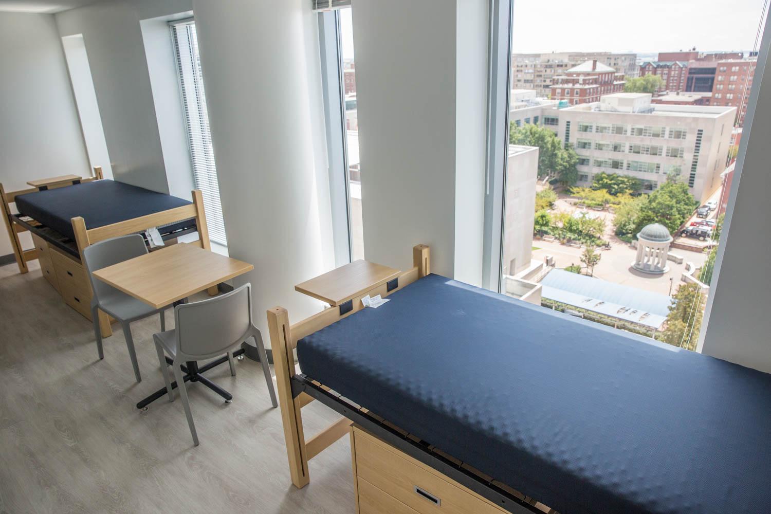 two lofted beds against window with view of Washington Monument
