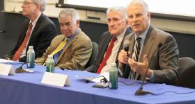 Men speaking on a panel