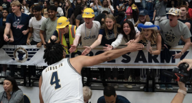 Fans and players high five at last month's game against Howard University. (Jess Rapfogel/GW Sports)