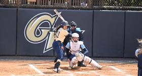 Softball player swinging bat