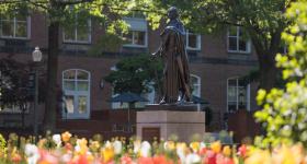 George Washington statue on the GW campus with flowers in the foreground