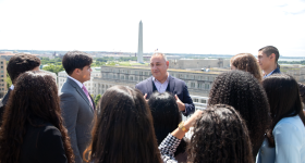 Gilbert Cisneros, B.A. ’94, spoke with students from the Caminos al Futuro on the terrace of the City View Room overlooking the Washington Monument. 