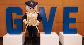 George mascot urges contributions on Giving Day.