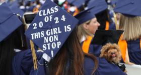 Girl with cap that says Class of 2024, this girl is non stop holding a golden doodle